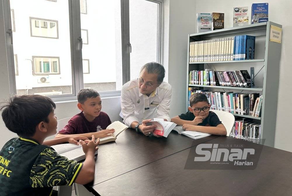 Mohamad sedang berbual dengan kanak-kanak yang membaca buku di Perpustakaan Wakaf Hajah Gayah ketika melawat perpustakaan itu pada Selasa.
