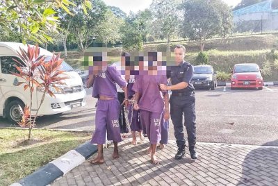 Suspek (kiri) tiba di pekarangan Mahkamah Alor Gajah di sini, pada Selasa.