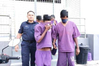 Suspek (dua, kiri) ketika dibawa ke keluar dari Mahkamah Alor Gajah di sini, pada Selasa.