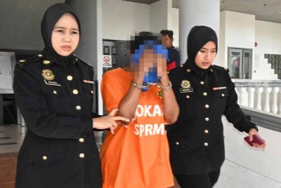 Suspek berusia 42 tahun (tengah) dibawa ke Mahkamah Majistret Melaka untuk direman pada Selasa.