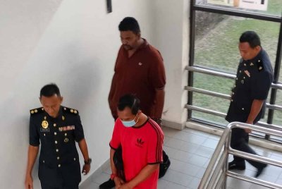 Mohd Suhaimy (dua, kiri) dan Vincent Rubin (dua, kanan) diiringi anggota KPDN sebaik selesai pertuduhan di Mahkamah Sesyen Sungai Petani pada Selasa.