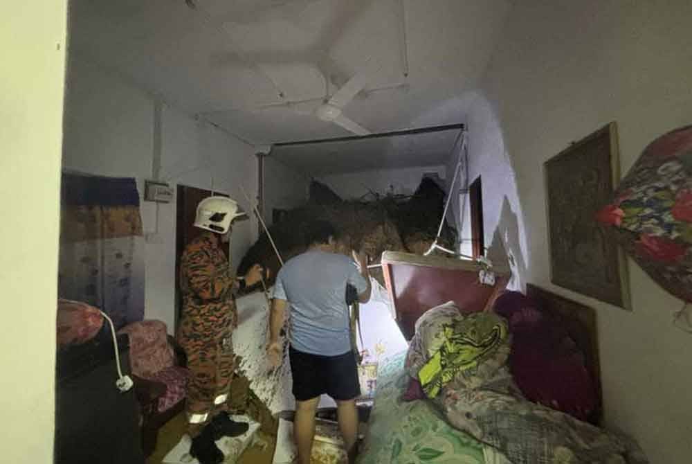 Runtuhan tanah berlaku di bahagian ruang tamu dan bilik utama salah sebuah kediaman terbabit, namun penghuninya sempat menyelamatkan diri. Foto JBPM Sarawak