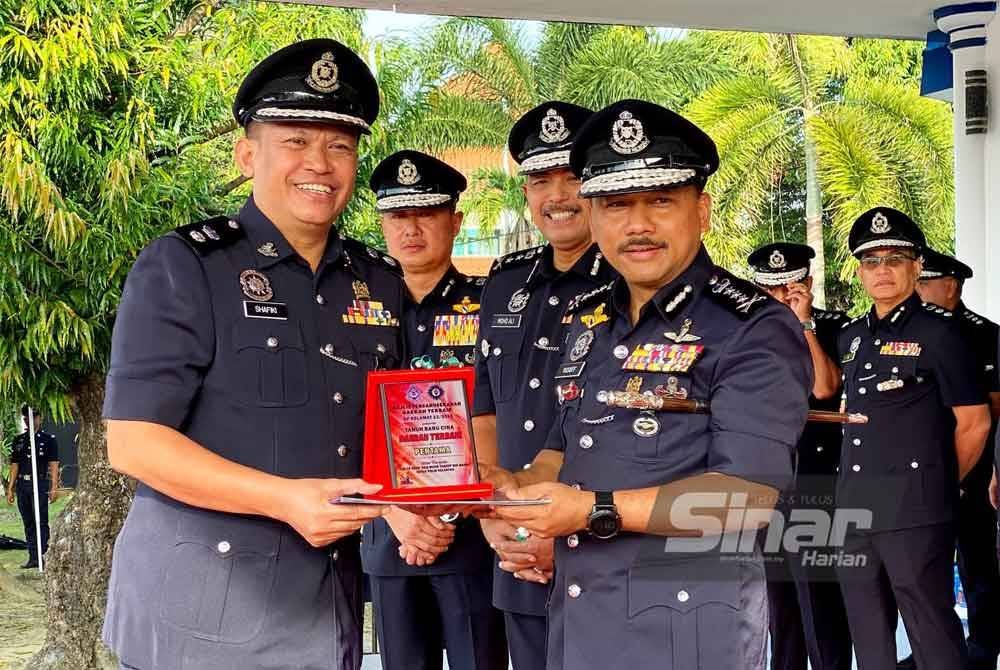 Mohd Yusoff (kanan) menyampaikan anugerah kepada Ketua Polis Daerah Machang, Ahmad Shafiki Hussin (kiri) apabila IPD Machang dinobatkan sebagai Daerah Terbaik Op Selamat 23/2025 sempena Tahun Baharu Cina. FOTO: SINAR HARIAN