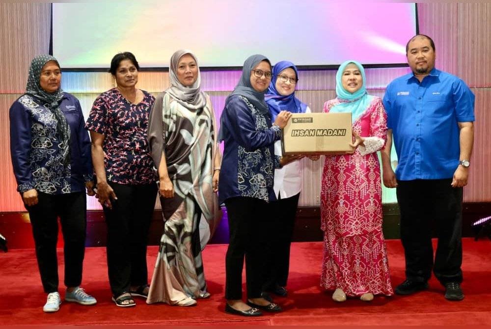 Faizah (dua dari kanan) menyerahkan bakul makanan kepada penerima sumbangan di Majlis Penyampaian Ihsan Madani di Hotel Seri Malaysia Kangar, Perlis.