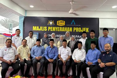 Mohd Fared (duduk, empat dari kiri) dan Mohd Jafni bergambar selepas Majlis Penyerahan Projek Pembangunan Tapak Perkuburan Islam Bandar Putra Kulai, Johor, pada Rabu.