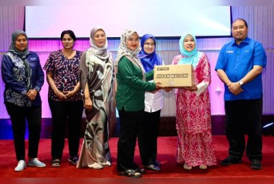 Faizah (dua dari kanan) menyerahkan bakul makanan kepada penerima sumbangan di Majlis Penyampaian Ihsan Madani di Hotel Seri Malaysia Kangar, Perlis.