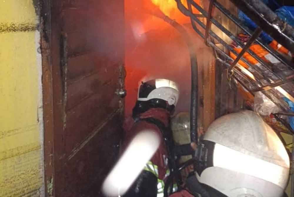 Anggota Bomba dan Penyelamat sedang memadamkan kebakaran sebuah rumah di Perumahan Awam Sri Terengganu.