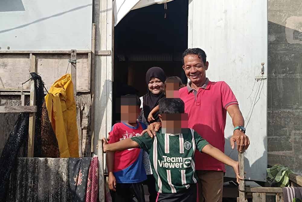Jani bersama keluarganya di hadapan rumah Kampung Darat Batu Rakit