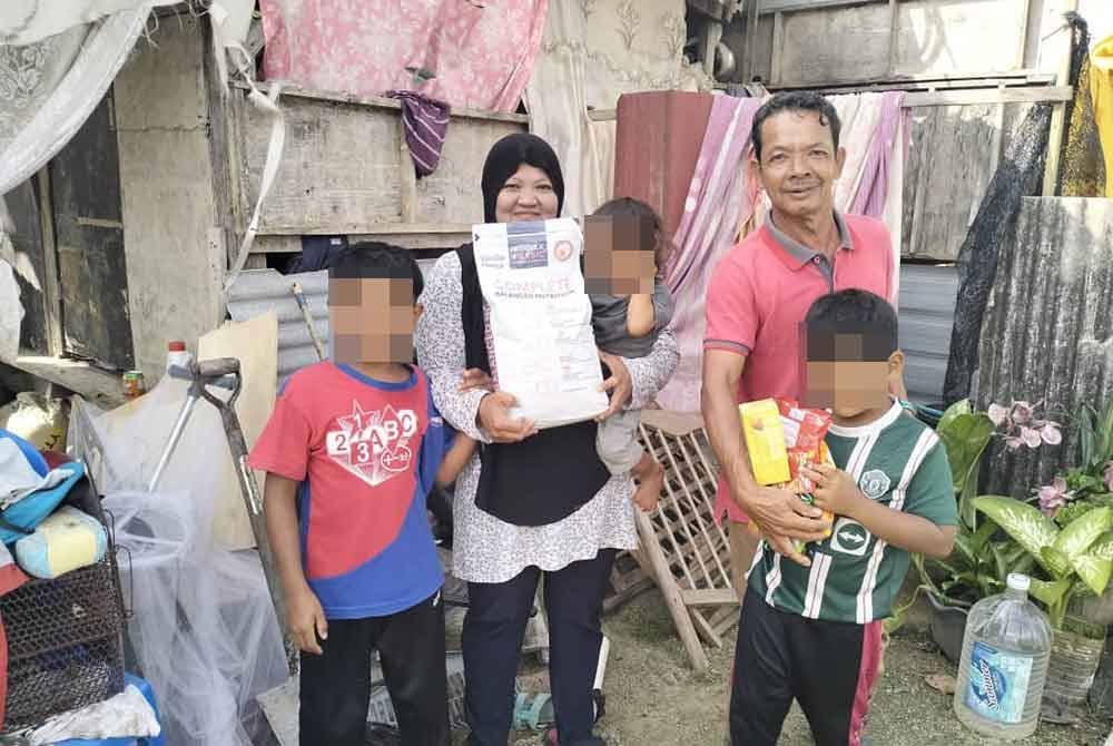 Jani bersama keluarganya di hadapan rumah Kampung Darat Batu Rakit