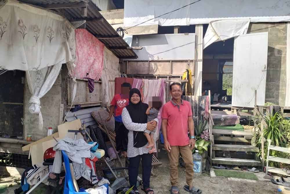 Jani bersama keluarganya di hadapan rumah Kampung Darat Batu Rakit