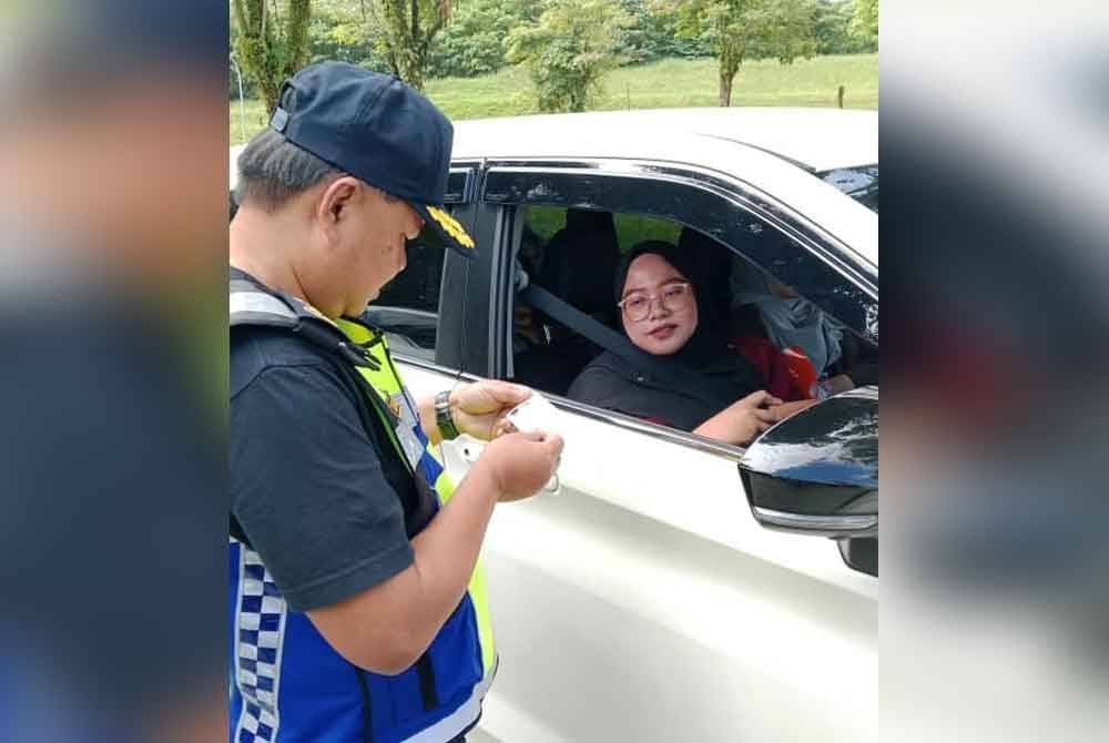 Ahmad Kamarunzaman memeriksa dokumen salah seorang pengguna ketika Operasi Penyamaran Khas sempena Tahun Baharu Cina di Hentian Rehat dan Rawat Rawang arah utara pada Khamis.