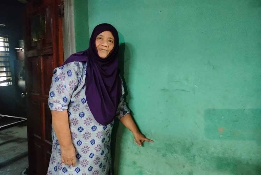 Manja menunjukkan ketinggian paras air ketika rumahnya di Kampung Baru Sungai Mas dilanda banjir.