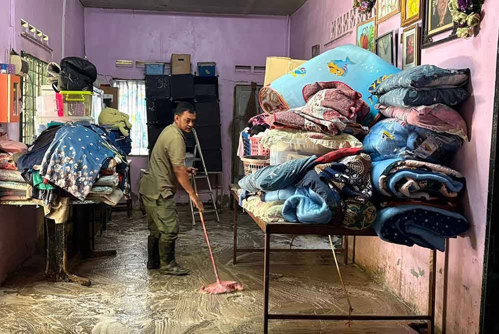Kerja pembersihan dilakukan di rumah Manja di Kampung Baru Sungai Mas selepas banjir surut sepenuhnya pada Khamis.