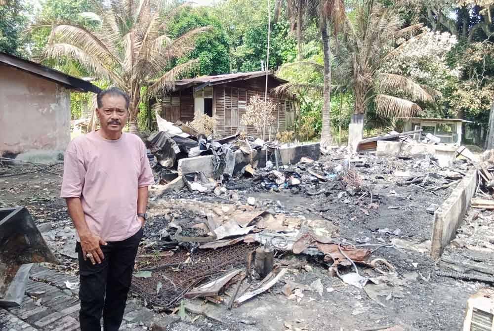 Azhar dihadapan rumah pusaka yang didiami sejak 20 tahun lalu hangus pada Selasa.