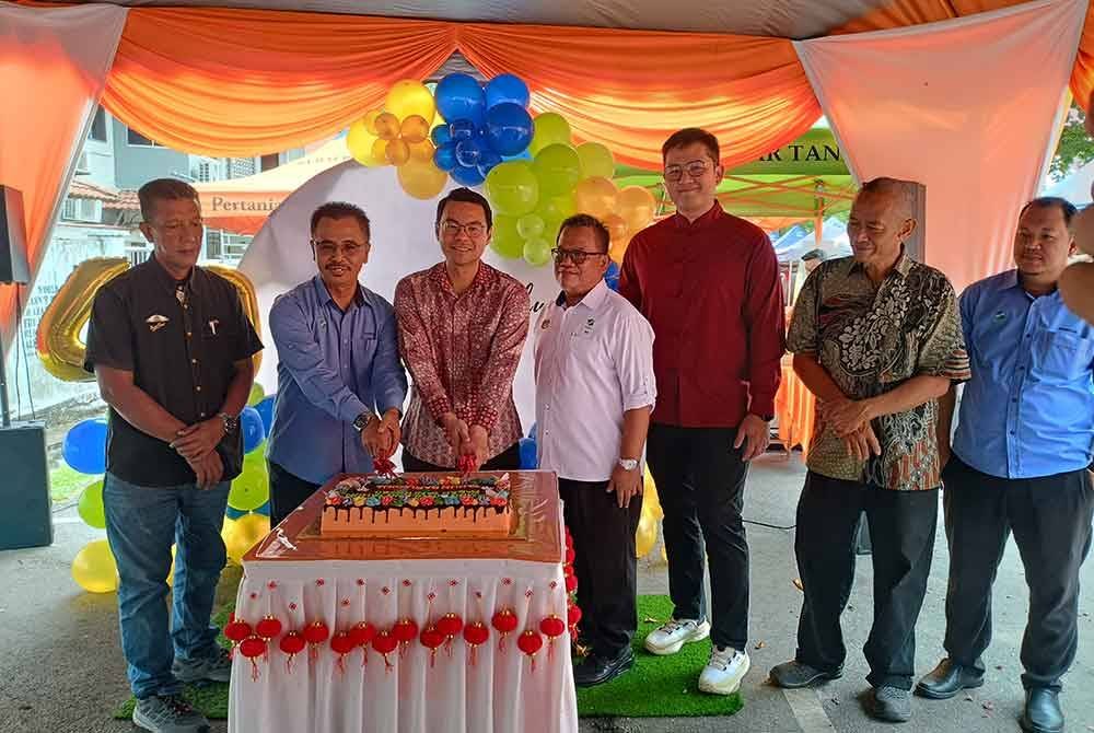 Abdul Rashid (dua dari kiri) dan Chen Chung (tiga dari kiri) memotong kek ketika majlis Sambutan Ulang Tahun Pasar Tani Ke-40 dan Tahun Baru Cina di pasar tani Seksyen 17 di sini, pada Khamis.