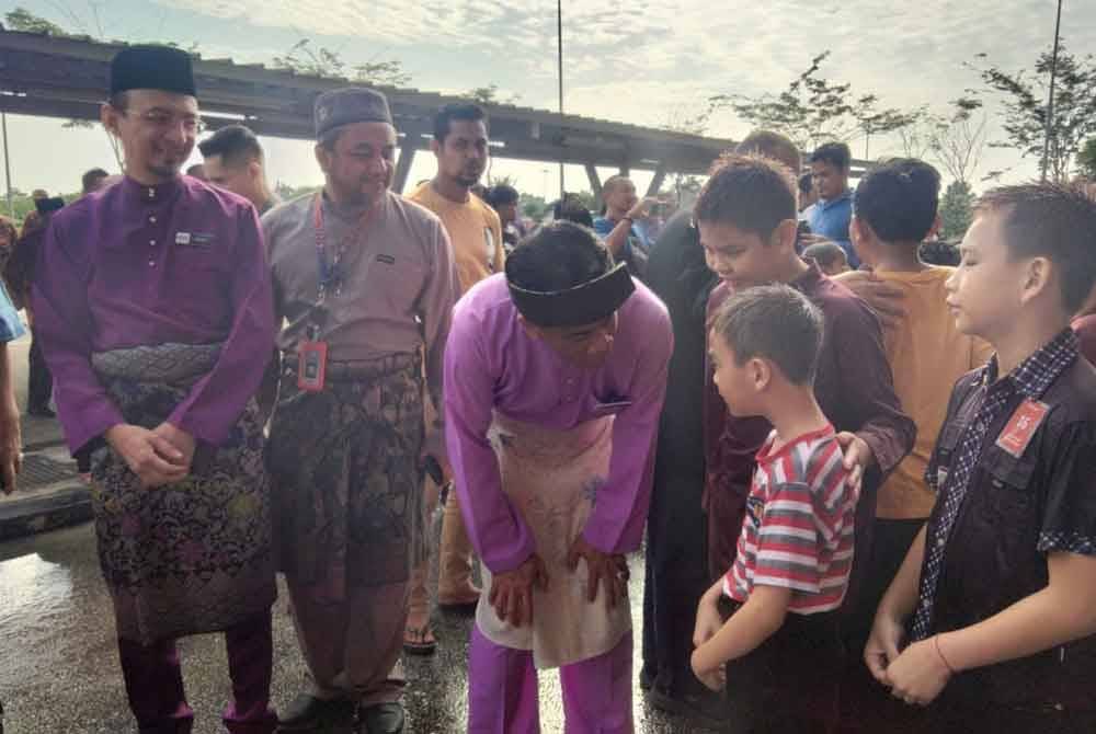 Dr Zaini (tiga dari kanan) bertanya khabar tiga beradik pada Program Khatan Hospital Tanah Merah 2025.