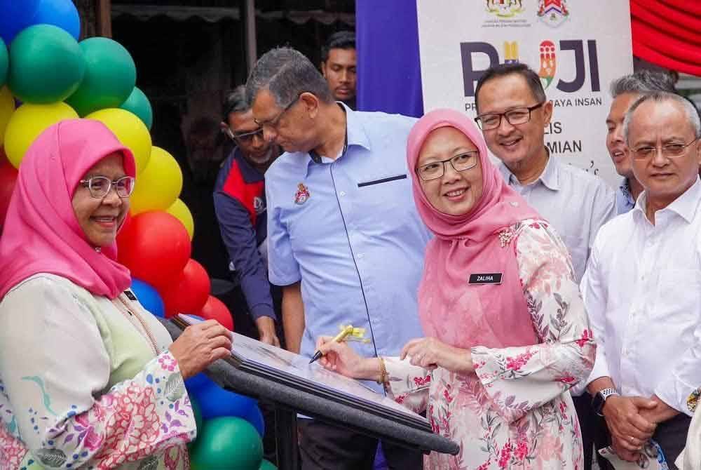 Zaliha menandatangani plak sebagai simbolik perasmian Barber Komuniti di PA Seri Perlis 2 pada Rabu.