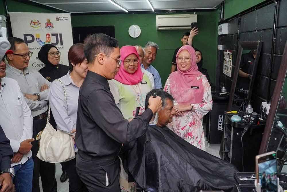 Zaliha (kanan) bersama Maimunah (dua dari kanan) meninjau operasi Barber Komuniti di PA Seri Perlis 2 pada Rabu.
