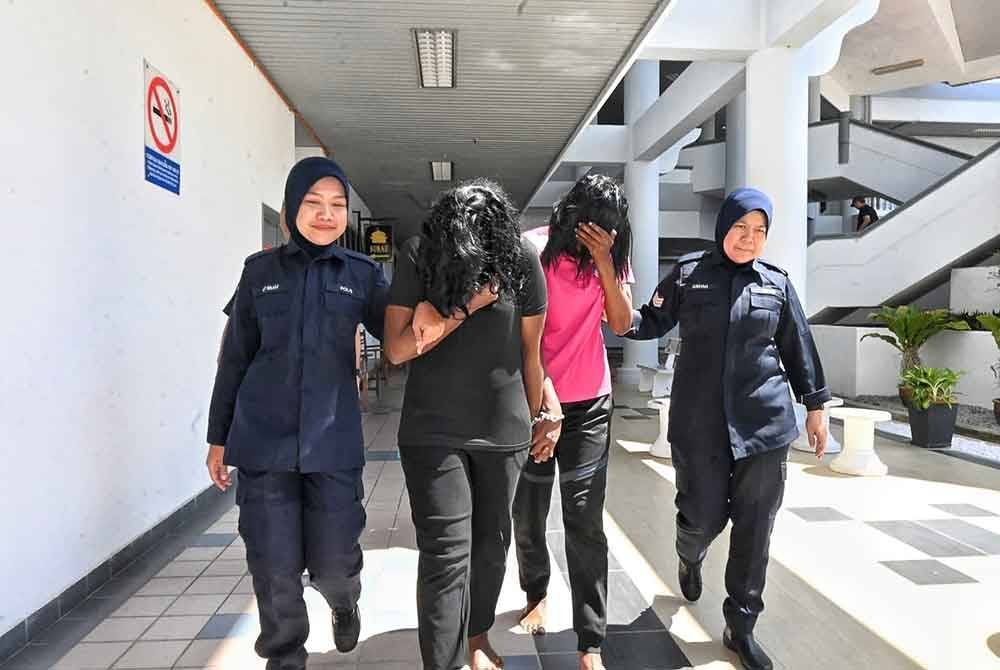 Tharshini (dua dari kiri) dan ibunya ketika dibawa keluar dari Mahkamah Majistret Melaka pada Khamis.