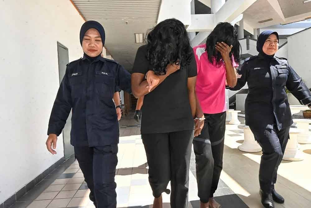 Tharshini (dua dari kiri) dan ibunya ketika dibawa keluar dari Mahkamah Majistret Melaka pada Khamis.