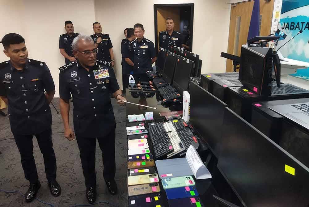 Ramli (dua kanan) melihat barangan yang dirampas.