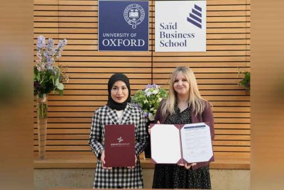 Adzliana bertukar-tukar dokumen MoU dengan Pengarah Bersekutu Program Pengajian Eksekutif SBS, Universiti Oxford, Corinne Young.