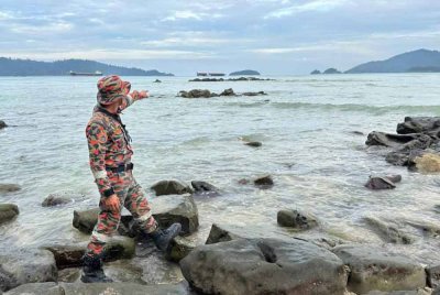Anggota bomba menunjukkan lokasi seorang lelaki dilaporkan hilang ketika mencari siput di Pantai Kebagu, di Kota Kinabalu pada malam Rabu.