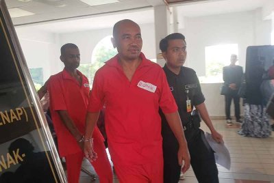 Tertuduh (tengah) ketika diiringi anggota Jabatan Penjara Malaysia ketika hadir di Mahkamah Bukit Mertajam, pada Khamis.