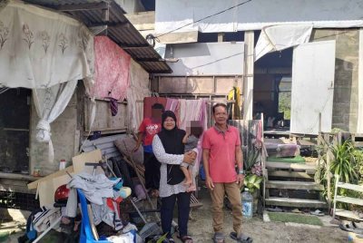 Jani bersama keluarganya di hadapan rumah Kampung Darat Batu Rakit
