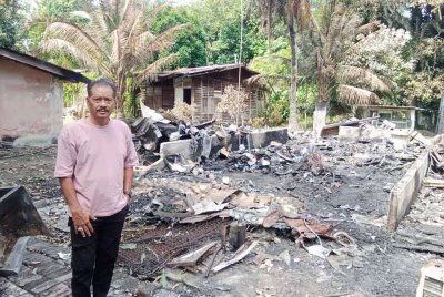 Azhar dihadapan rumah pusaka yang didiami sejak 20 tahun lalu hangus pada Selasa.