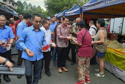 Abdul Rashid dan Chen Chung melawat gerai jualan usahawan FAMA di pasar tani Seksyen 17 di sini, pada Khamis.