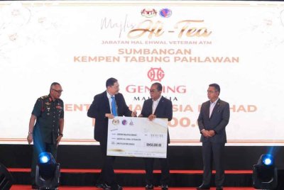 Thiam Kit (dua dari kiri) menyerahkan sumbangan tabung pahlawan berjumlah RM50,000 kepada Mohamed Khaled sambil disaksikan oleh Adly (kanan).