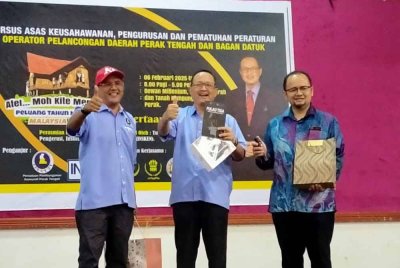 Mustaffa Kamil (tengah) menerima cenderahati selepas menyempurnakan penutupan Kursus Asas Kemahiran dan Keusahawanan Serta Pematuhan Peraturan Operator Pelancongan Daerah Perak Tengah dan Bagan Datuk di Dewan Millenium, Pejabat Daerah dan Tanah Kampung Gajah pada Khamis.