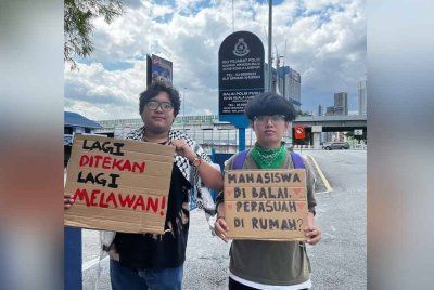 Danny Villenguez (kiri) bersama seorang aktivis mahasiswa di hadapan IPD Wangsa Maju ketika mengiringi rakan mereka memberi keterangan kepada polis baru-baru ini.