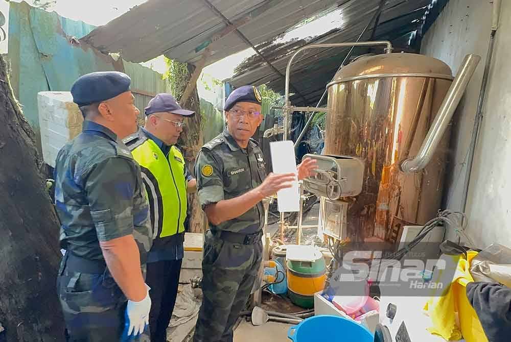 Shahrum (kanan) memeriksa mesin memproses sisa e-waste yang baru dibeli oleh pemilik kilang itu.