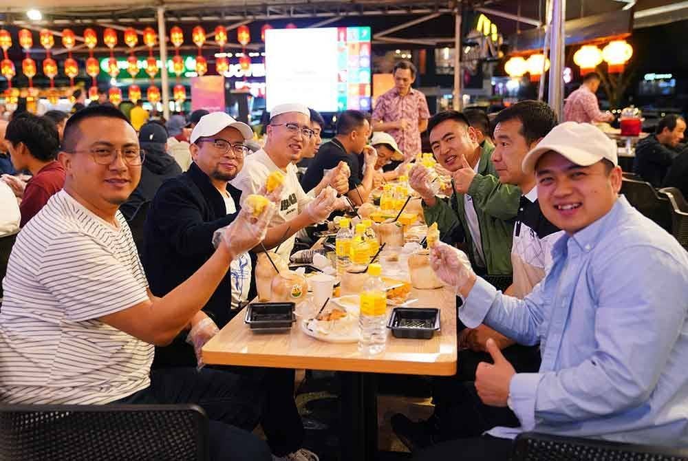 Antara peserta program pertukaran budaya anjuran ITC dan MICA menikmati durian. - FOTO: SINAR HARIAN / MOHD HALIM ABDUL WAHID.