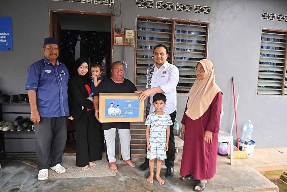 Ahmad Farhan menyerahkan sumbangan berupa wang tunai dan bakul makanan kepada Salim. Foto Facebook Anwar Ibrahim