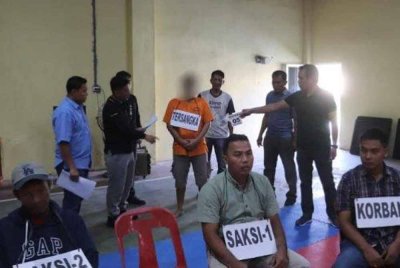 Pelaku ketika dibawa ke lokasi bagi menceritakan semula kejadian pembunuhan itu. Foto Agensi