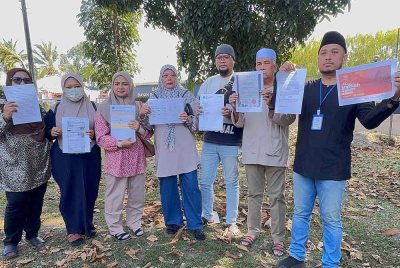 Mohd Hilmi (kanan) bersama beberapa jemaah lain membuat 10 laporan polis di Balai Polis Bayan Baru terhadap syarikat agensi umrah yang didakwa menipu jemaah.