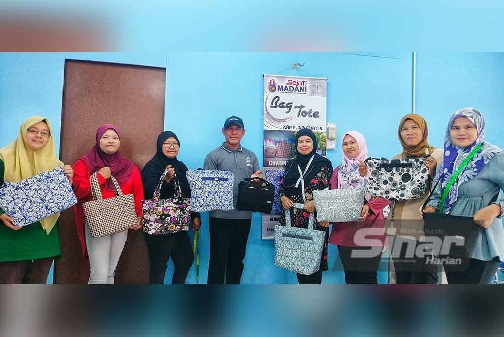 Jamal (empat dari kiri) bersama sebahagian peserta bengkel yang menghasilkan beg jenama ‘Laa Chatine’ di Kampung Chatin.
Foto Sinar Harian