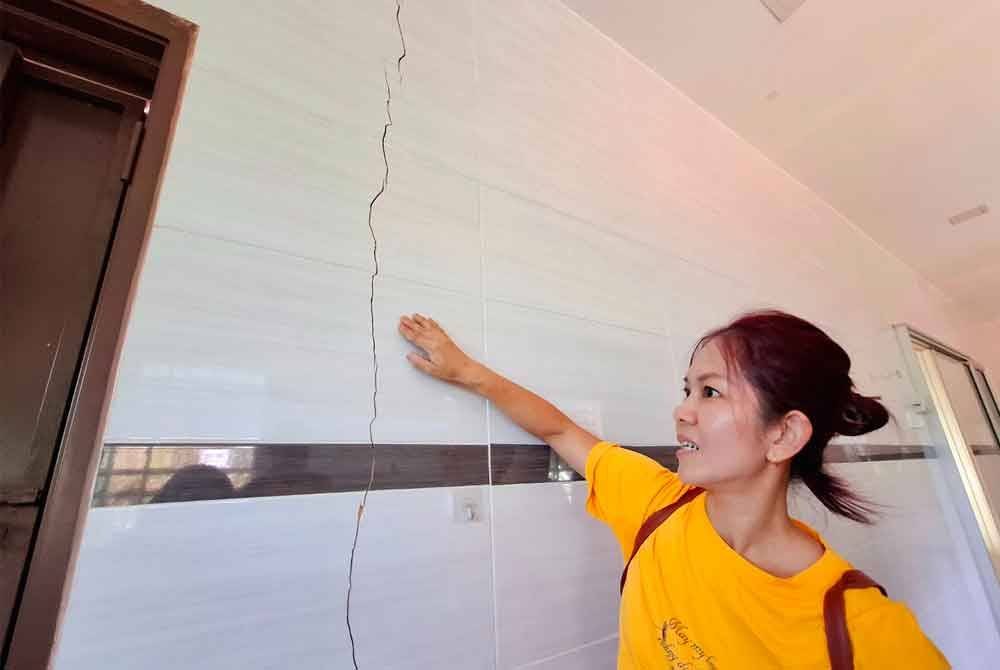 Lai Yun menunjukkan kesan baharu rekahan di dinding rumahnya susulan kejadian tanah runtuh di Taman Bunga Raya dekat Tapah Isnin lalu.