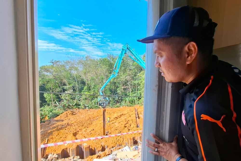 Fahmi melihat kesan runtuhan bahagian dapur rumahnya dalam kejadian tanah runtuh di Taman Bunga Raya dekat Tapah.