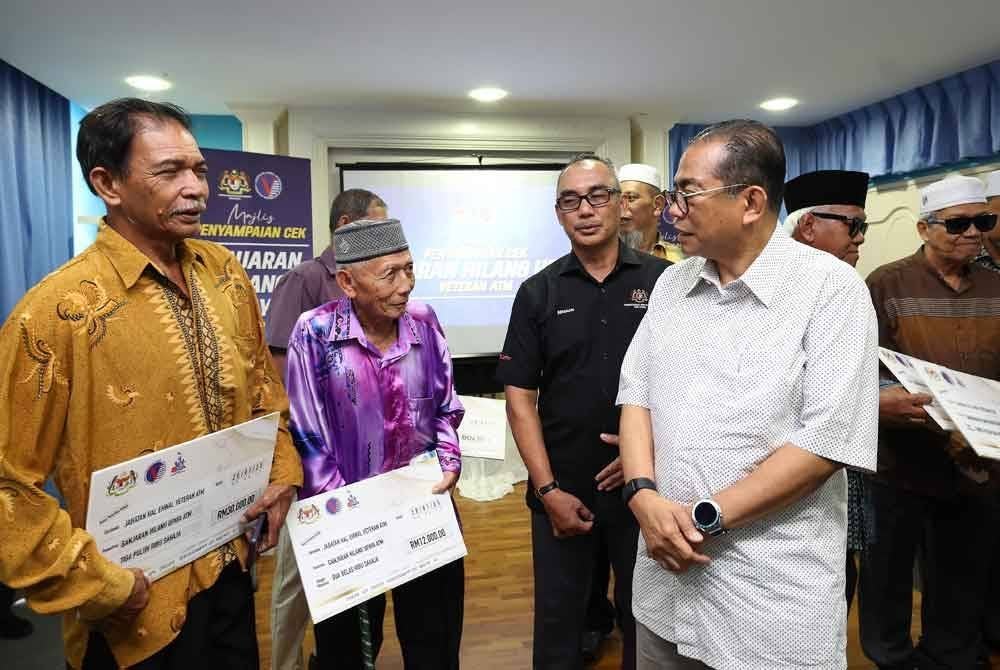 Mohamed Khaled beramah mesra dengan veteran Angkatan Tentera Malaysia (ATM) yang menerima cek ganjaran pada Majlis Penyampaian Cek Ganjaran Hilang Upaya Veteran ATM di Bangunan UMNO Bahagian Muar pada Sabtu. Foto Bernama