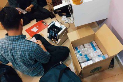 Pegawai imigresen menjalankan pemeriksaan di lokasi serbuan.