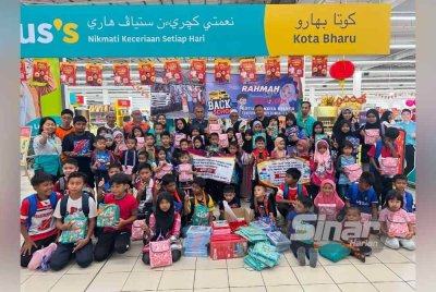 Penerima bergambar selepas selesai membeli kelengkapan persekolahan di Pasar Raya Lotus’s Kota Bharu pada Sabtu.