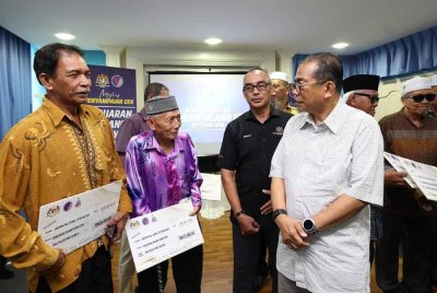 Mohamed Khaled beramah mesra dengan veteran Angkatan Tentera Malaysia (ATM) yang menerima cek ganjaran pada Majlis Penyampaian Cek Ganjaran Hilang Upaya Veteran ATM di Bangunan UMNO Bahagian Muar pada Sabtu. Foto Bernama
