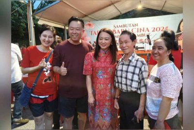 Hannah (tengah) bergambar bersama pengunjung pada Sambutan Tahun Baharu Cina Parlimen Segambut 2025 di Taman Tasik Manjalara pada Sabtu.