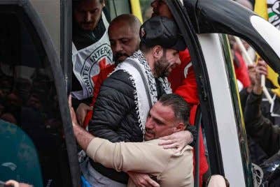 Seorang bekas tahanan Palestin dipeluk oleh seorang lelaki ketika dia bersiap untuk keluar dari bas di bandar Ramallah, Tebing Barat yang diduduki pada 8 Februari 2025, sebagai sebahagian daripada pertukaran tebusan-tahanan yang kelima di bawah gencatan senjata rapuh Gaza. Foto AFP