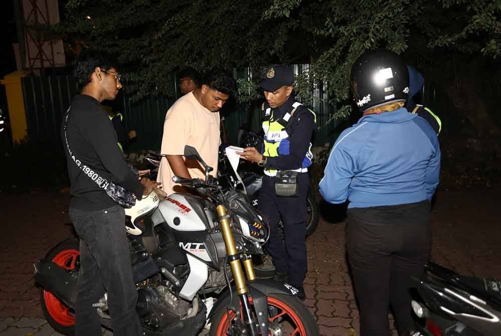 Anggota JPJ Perak memeriksa dokumen penunggang motosikal sempena Op Khas Tahun Baharu Cina di Ipoh pada Sabtu.