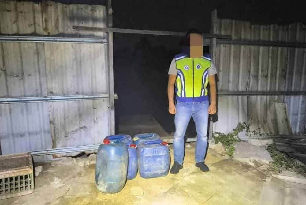 Anggota PGA menunjukkan tong mengandungi petrol ketika menyerbu sebuah stor simpanan di Kampung Tualang, Tumpat pada Sabtu.